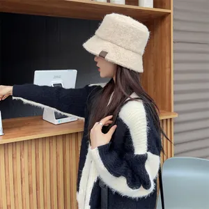 Stylish woman wearing a cozy cream plush bucket hat with a decorative patch detail
