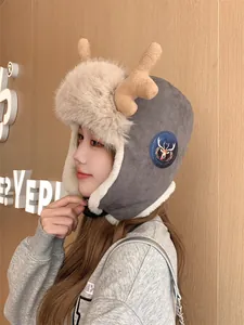 Detail of a grey winter trapper hat with plush faux fur and reindeer antlers on a model.