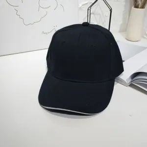 Classic black baseball cap with white sandwich trim detail in minimalist lifestyle room.