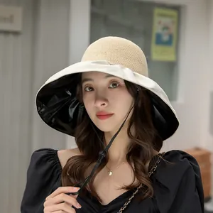 Wide brim UV protection straw sun hat for women with black glue lining and chin strap.