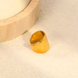 Detailed view of a minimalist wide gold stainless steel C-shaped ear cuff on stone