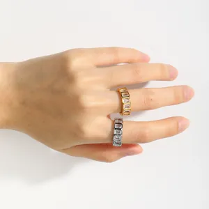 Detailed view of hand wearing gold and silver stainless steel rings with white zircons