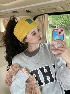 Detailed view of the stylish yellow knitted headband worn in a casual car lifestyle setting