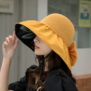 Stylish women's yellow sun hat with large bow and black lining for UV protection