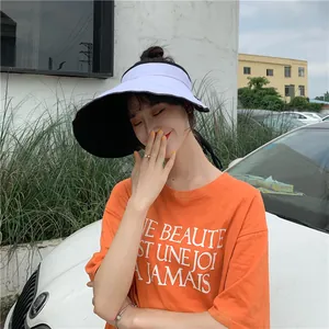 Femme portant une visière pare-soleil double face blanche et noire très élégante