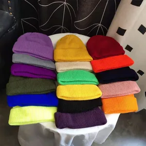 A colorful collection of short knit beanie hats displayed in various vibrant shades