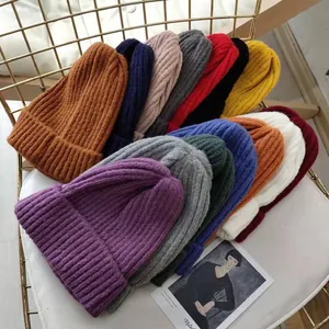Detailed close-up view of various colorful ribbed knit beanies for cold winter seasons
