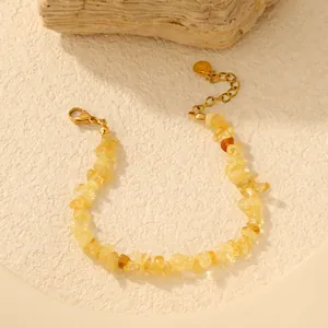 Détail d'un bracelet en éclats de cristal jaune naturel avec chaîne en acier doré.