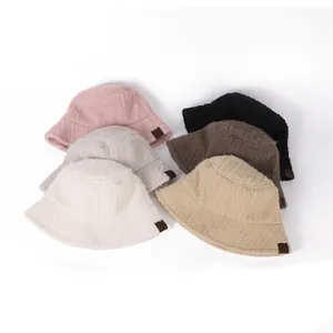 Group of thick plush bucket hats in multiple warm colors for winter styling