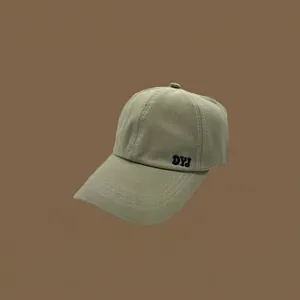 Gros plan d'une casquette de baseball vert olive brodée DYJ sur fond marron.