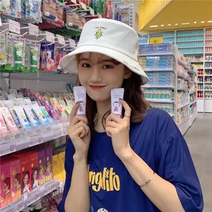 Detailed view of a white bucket hat with cute corn embroidery worn by a model