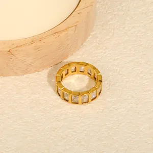 Detail of a luxury gold-plated stainless steel ring with rectangular white zircons
