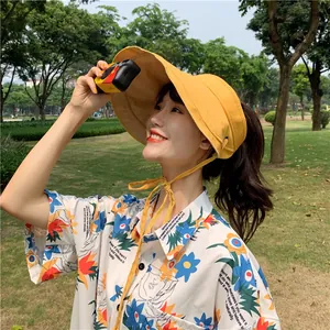 Gros plan d'un mannequin portant un chapeau pare-soleil en lin jaune dans un parc naturel