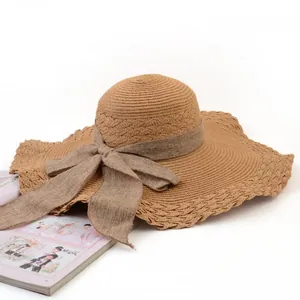 Close-up of a wide-brimmed straw sun hat with an elegant decorative bowknot