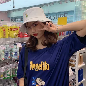 Detailed view of a white bucket hat with cute corn embroidery worn by a model