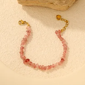 Détail d'un bracelet en pierres de cristal naturel rose avec chaîne en acier inoxydable doré