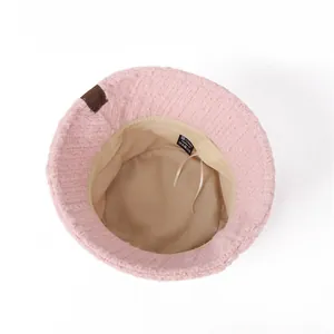 Detailed interior view of a pink plush winter bucket hat with adjustable beige lining