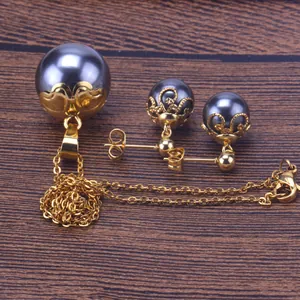 Vista detallada de elegante conjunto de collar y pendientes de perlas negras en madera