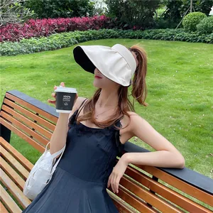 Detailansicht einer Frau mit einem stylischen beigen Sonnenhut mit breiter Krempe