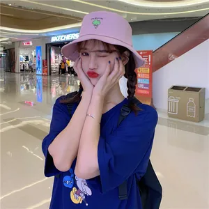 Young Asian model wearing a pink bucket hat with cute broccoli embroidery in a mall