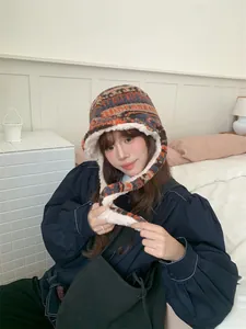 Close-up of woman wearing a thick Fair Isle plush trapper hat with earflaps and ties