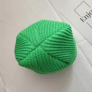 Top-down detailed view of a vibrant green knitted beanie featuring a ribbed texture