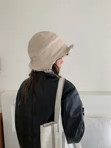 Vue latérale détaillée d'un chapeau d'aviateur beige pour femme avec protège-oreilles