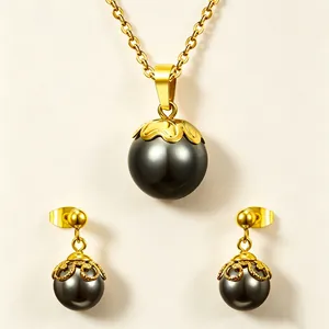 Elegante conjunto de joyas con collar de perlas negras y pendientes en acabado dorado.