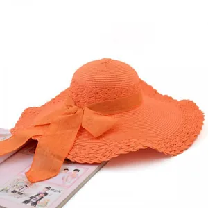 Orange wide-brimmed straw sun hat with decorative bow, summer beach style detail