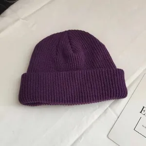 Close-up of the purple knitted beanie showing fine ribbing and cuffed detail
