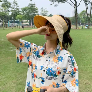 Détail lifestyle d'un chapeau de soleil en lin porté par un mannequin en plein air.