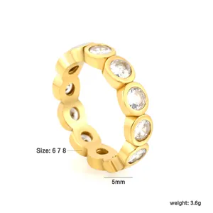 Detail view of golden stainless steel eternity ring with circular white zirconia stones