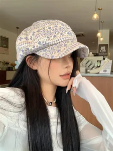 Woman wearing a knitted newsboy hat with snowflake pattern in a cozy cafe setting
