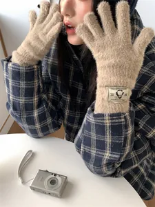 Vista dettagliata dei guanti in maglia beige pelosi da donna con toppa di pinguino