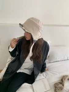 Vue latérale d'une femme portant un bonnet d'aviateur en daim beige pour l'hiver