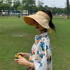 Détail d'une visière pare-soleil en lin beige pour femme avec liens jaunes, protection UV.