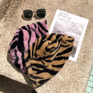 Detail view of stylish tiger stripe plush bucket hats in pink and brown faux fur