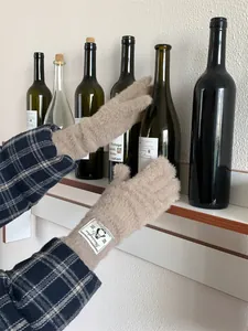 Guanti invernali in morbido peluche con dettaglio etichetta pinguino in una scena