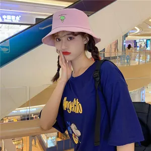 Stylish pink bucket hat with cute broccoli embroidery worn by an Asian model in a mall detail