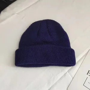Macro view showing the texture of navy blue knitted short beanie unisex melon cap