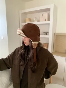 Chapeau de trappeur en daim marron avec doublure polaire chaude sur le profil d'un modèle