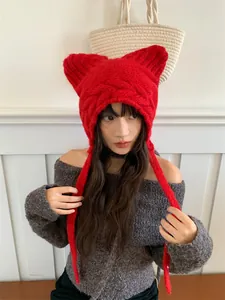 Detailed view of a cute red knitted cat ear hat for women, winter ear protection.