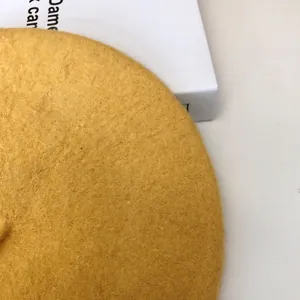 Detailed macro view of a yellow wool beret showcasing its soft felt fiber texture