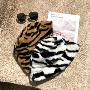 Pair of stylish faux fur bucket hats with zebra and tiger animal patterns for winter