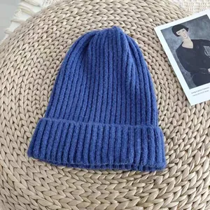 Detail view of the soft ribbed texture on a classic blue knitted winter beanie hat.