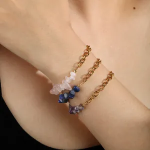 Détail de bracelets dorés avec éclats de cristaux naturels irréguliers au poignet.