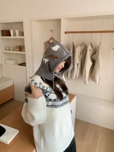 Close-up of gray knitted cartoon balaclava with cute animal pattern shown on model