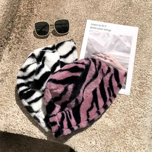Detail view of plush faux fur bucket hats with stylish zebra stripes in pink and white