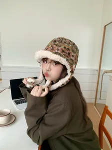 Asian model wearing a cozy Fair Isle plush trapper hat with ear flaps in a home setting