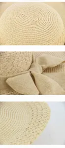 Detail view of a straw sun hat showing the crown texture and elegant fabric bow decoration